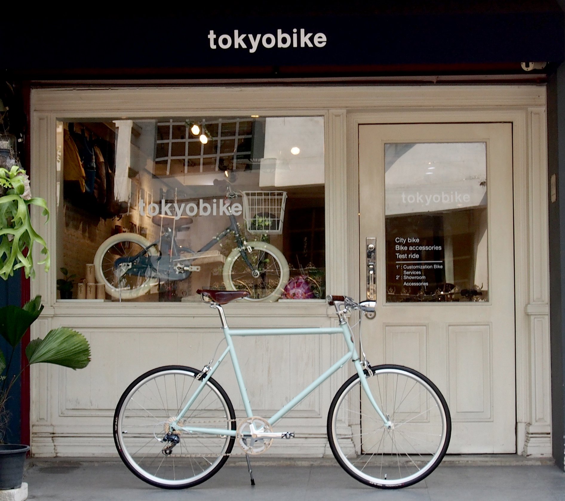 จักรยาน โตเกียวไบค์ tokyobike plus แต่งเบาะหนัง brooks สีน้ำตาล ตัดกับเฟรมสี mint และติดไฟหน้าจักรยานวินเทจ ที่คอด้านหน้า